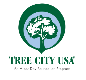 Tree City USA logo with green and white tree, surrounded by blue and green band, with the words underneath "Tree City USA: An Arbor Day Foundation Program"
